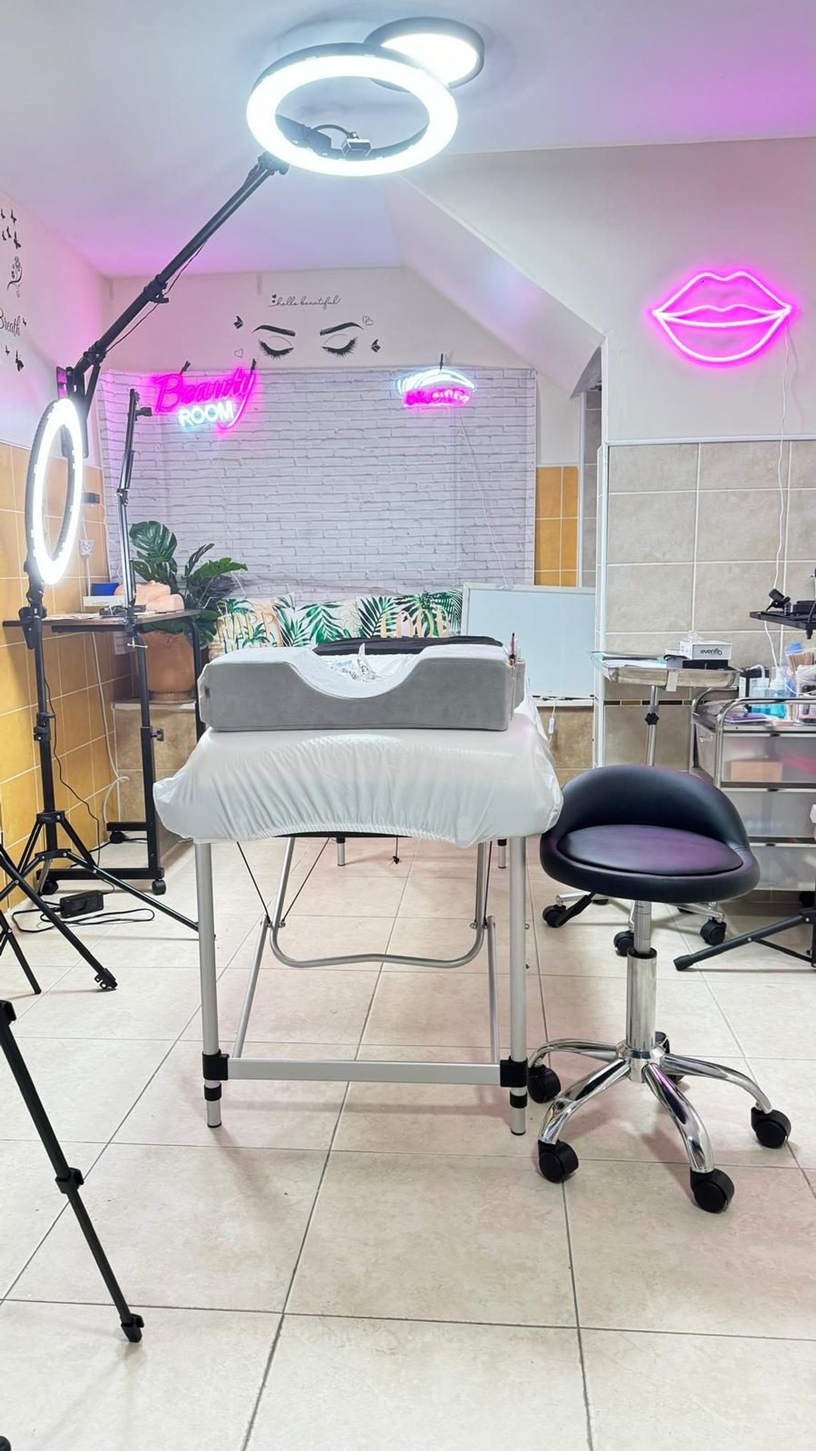 Kyara Luxe private beauty room in NYC with ring lights, treatment bed and neon Beauty Bar signage